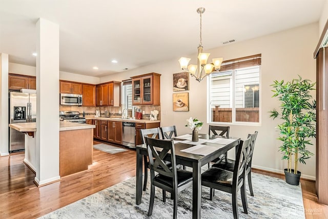 dining area with visible vents, light wood-style flooring, recessed lighting, baseboards, and a chandelier