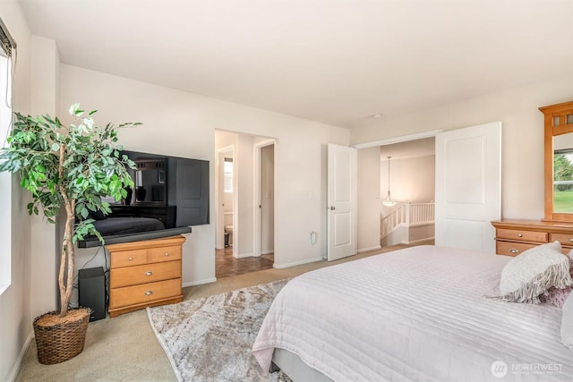 bedroom with light colored carpet and baseboards