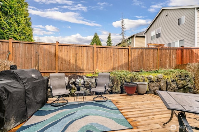 deck featuring area for grilling and a fenced backyard