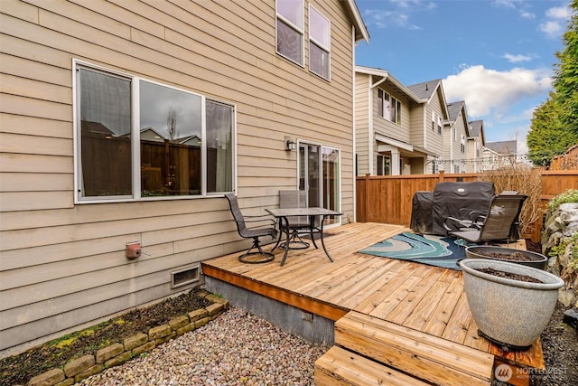 wooden terrace with fence, a residential view, and grilling area