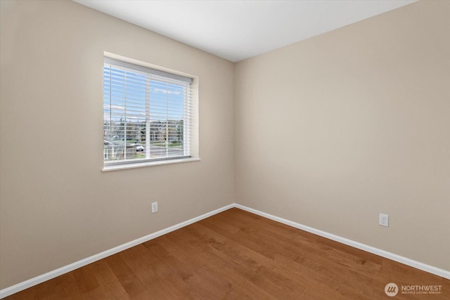 unfurnished room with baseboards and wood finished floors