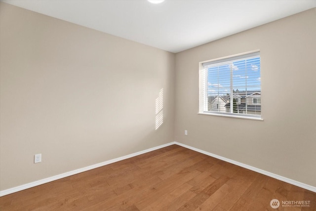 spare room featuring wood finished floors and baseboards