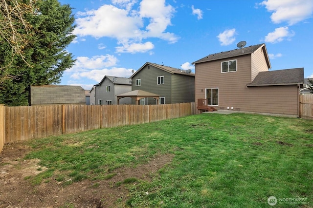 rear view of property featuring a lawn and a fenced backyard