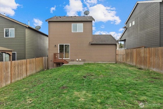 back of house with a fenced backyard and a yard