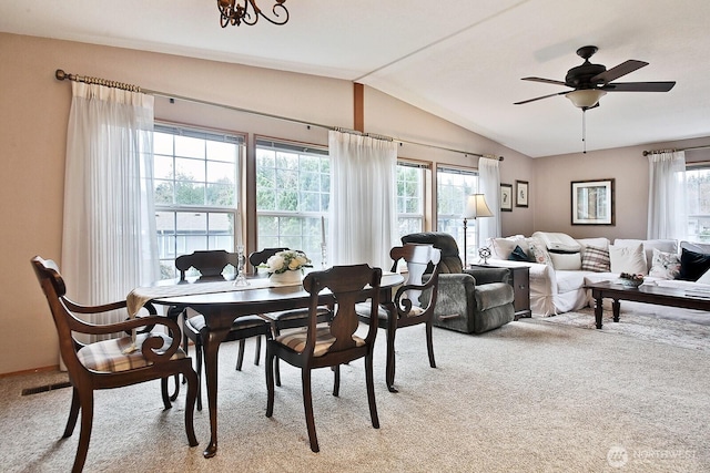 dining area featuring a ceiling fan, vaulted ceiling, light colored carpet, and a wealth of natural light