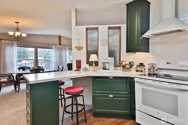 kitchen with electric stove, a peninsula, wall chimney range hood, green cabinetry, and lofted ceiling