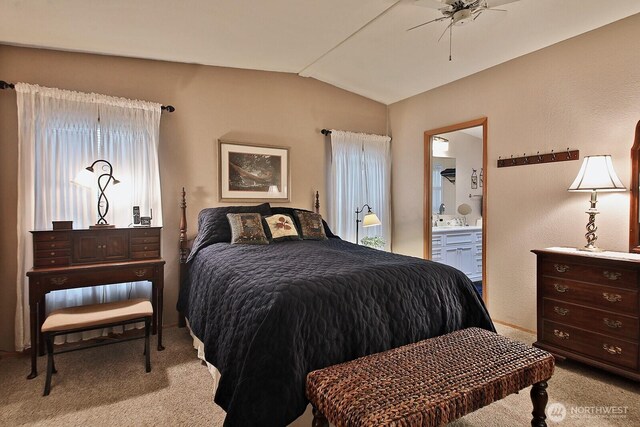 bedroom featuring ceiling fan, ensuite bathroom, lofted ceiling, and carpet floors