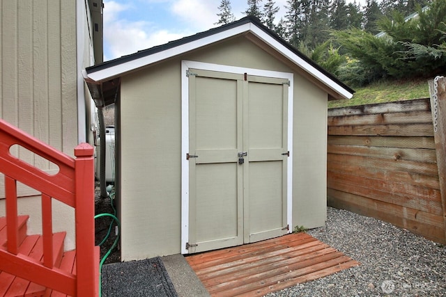 view of shed featuring fence