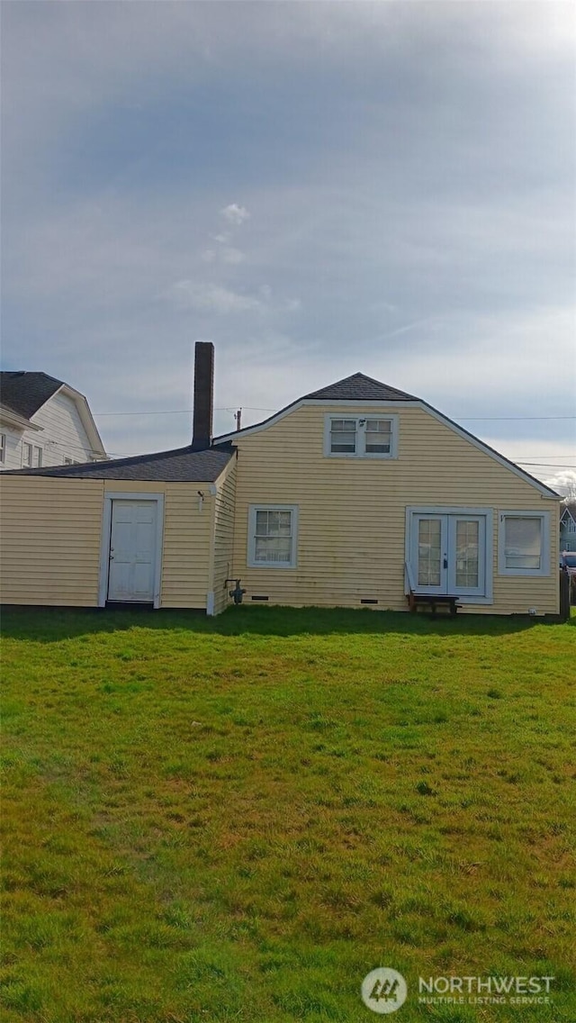 rear view of house featuring a yard