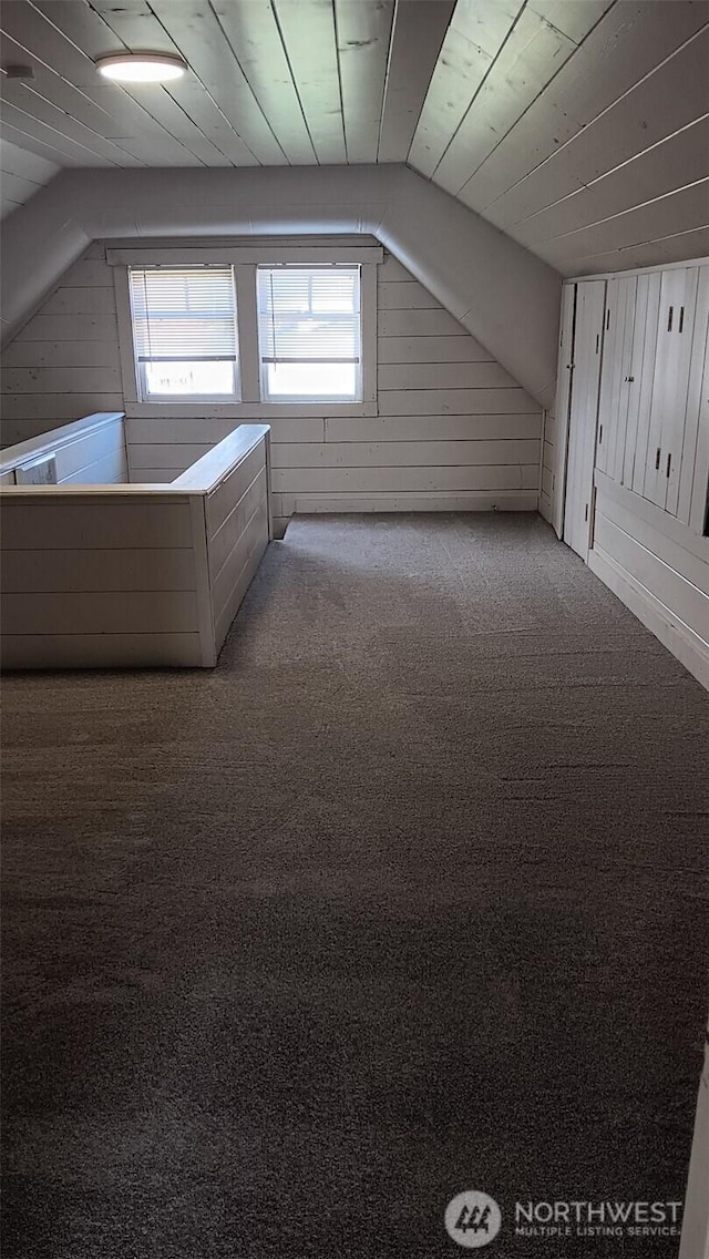 bonus room with wooden ceiling, wood walls, carpet flooring, and vaulted ceiling