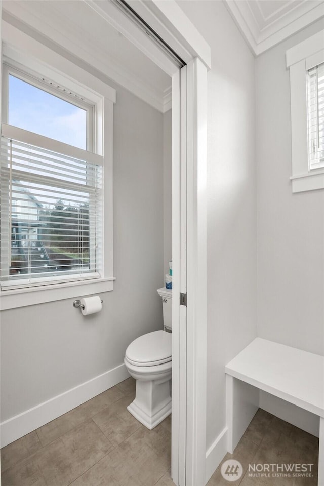 bathroom with ornamental molding, tile patterned flooring, baseboards, and toilet