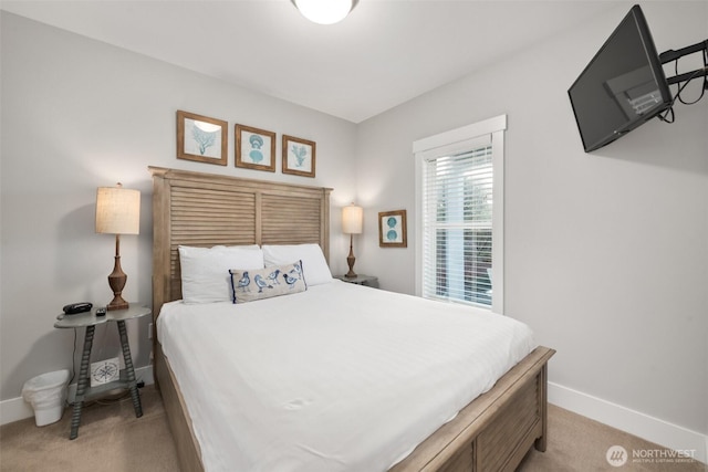 bedroom featuring light carpet and baseboards