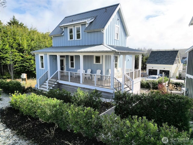 view of front of house featuring an outbuilding, metal roof, a porch, and board and batten siding