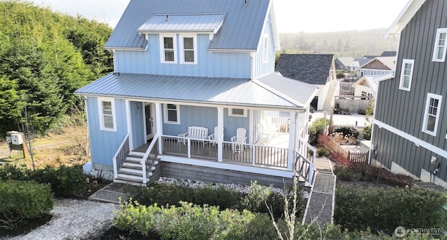 view of front facade with a porch, metal roof, and stairs