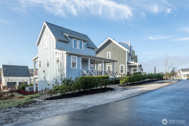 view of front facade featuring covered porch, metal roof, and board and batten siding