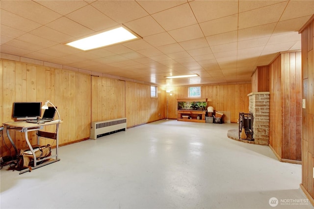 basement featuring wooden walls and radiator heating unit