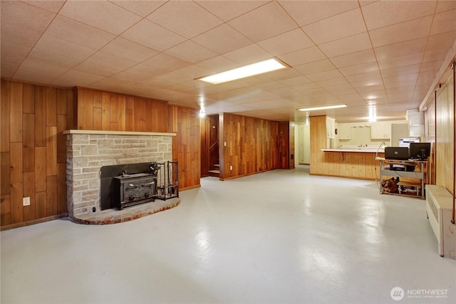 interior space featuring baseboards, finished concrete flooring, and wood walls