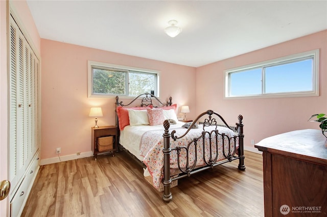 bedroom featuring a closet, baseboards, and light wood finished floors