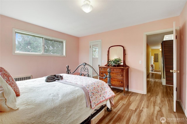 bedroom featuring visible vents, baseboards, and light wood-style floors