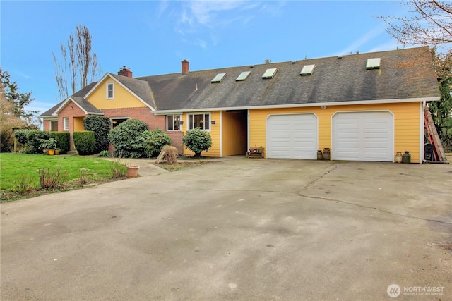 view of front of house with a shingled roof, concrete driveway, a front yard, a chimney, and a garage