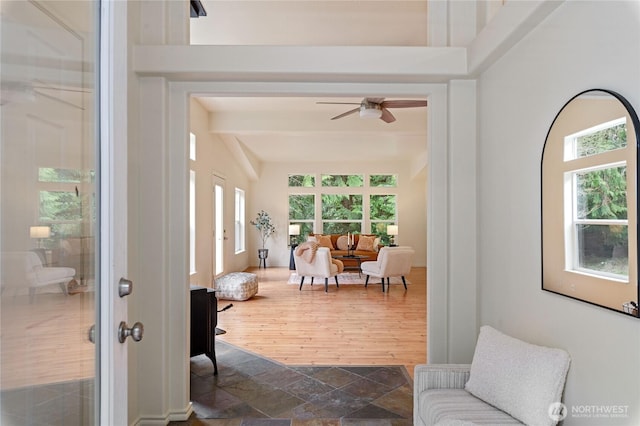 sunroom featuring beamed ceiling and ceiling fan