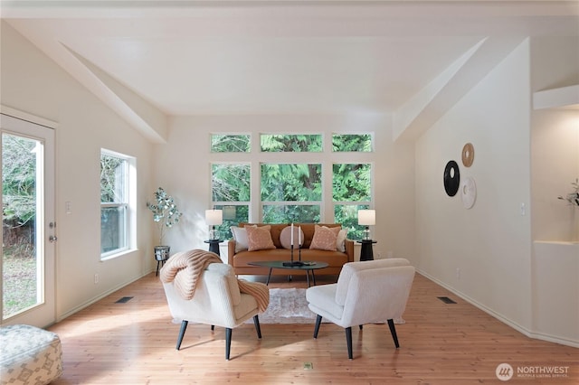 living room featuring visible vents, baseboards, and light wood-style floors