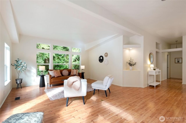 living room with visible vents, baseboards, and light wood-style floors