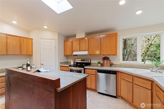 kitchen featuring a sink, under cabinet range hood, recessed lighting, appliances with stainless steel finishes, and light countertops