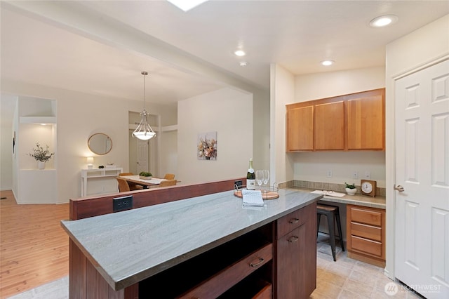 kitchen featuring recessed lighting, a center island, hanging light fixtures, and light countertops