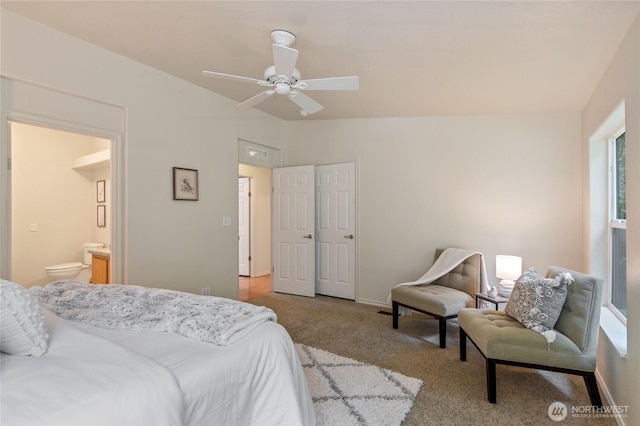 bedroom with ensuite bath, baseboards, carpet, and vaulted ceiling