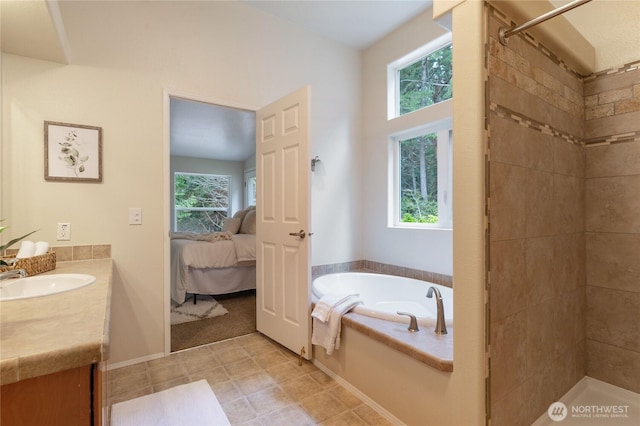 bathroom featuring tiled shower, plenty of natural light, and vanity