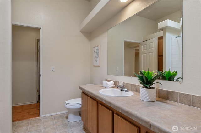 full bathroom with vanity, toilet, and baseboards