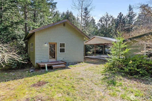 rear view of property with a lawn and a carport