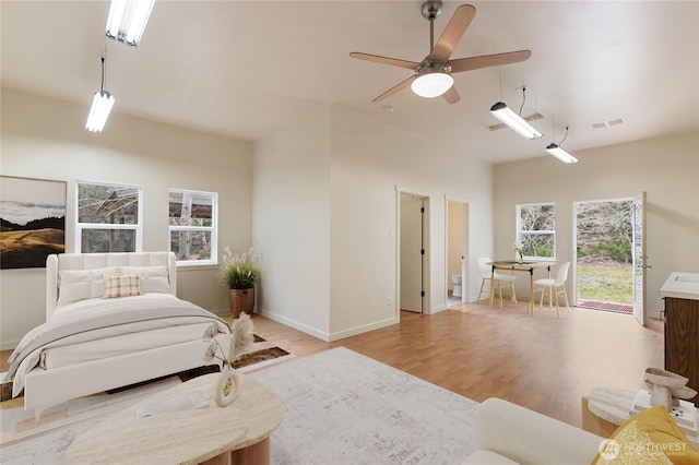 bedroom featuring a ceiling fan, light wood-style floors, and baseboards