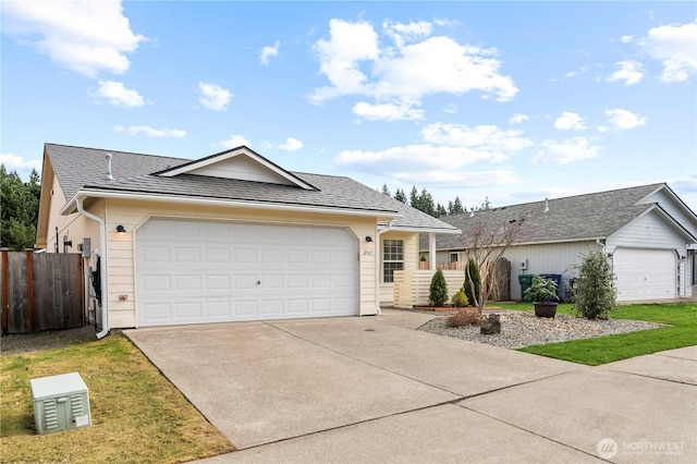 ranch-style house featuring driveway, a shingled roof, a garage, and fence