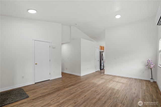 unfurnished room featuring vaulted ceiling, baseboards, and wood finished floors