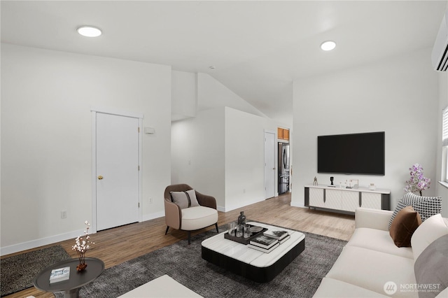 living area featuring baseboards, wood finished floors, and vaulted ceiling