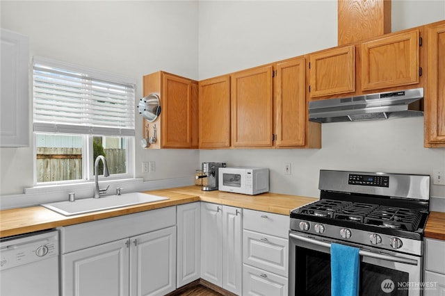 kitchen featuring under cabinet range hood, wood counters, white appliances, and a sink