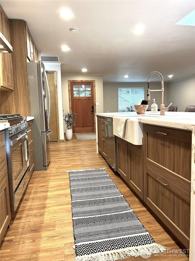 kitchen with light countertops, light wood-type flooring, and appliances with stainless steel finishes