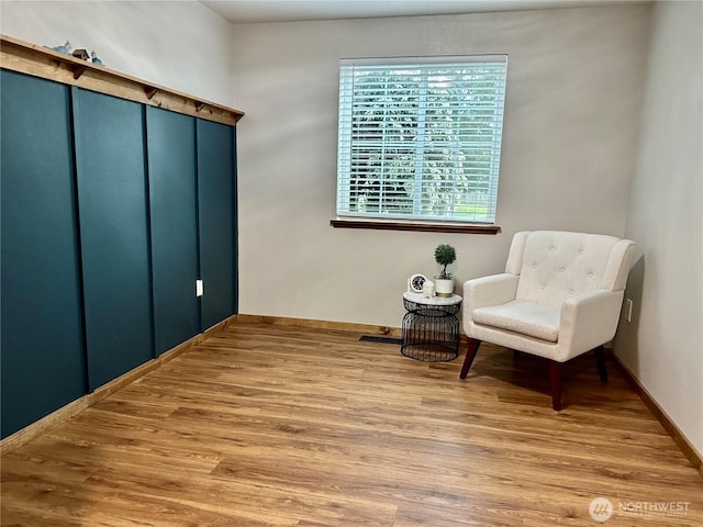 sitting room featuring baseboards and wood finished floors