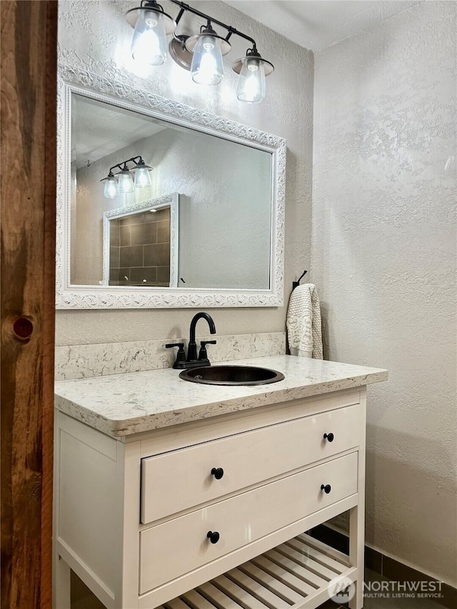 bathroom featuring vanity and a textured wall