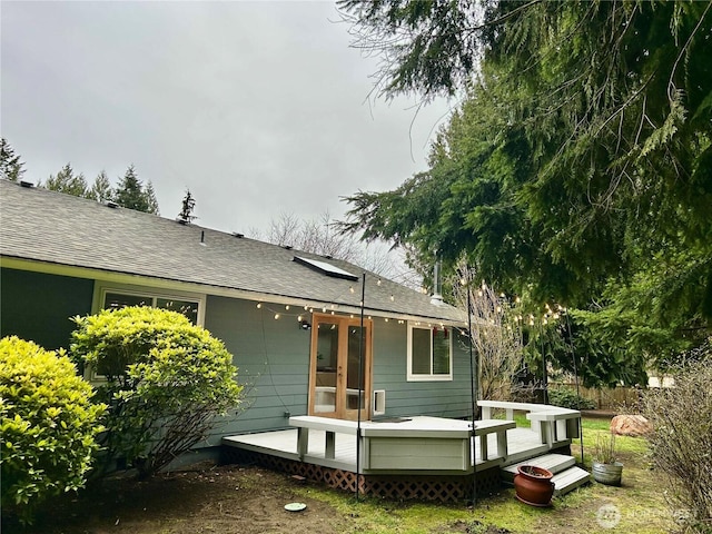 rear view of house featuring french doors, fence, a deck, and roof with shingles