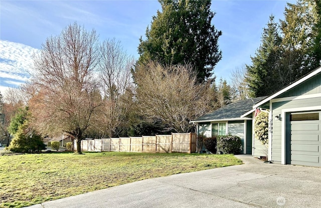 view of yard featuring an attached garage and fence