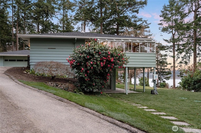 view of front of house with a front yard, a garage, and a sunroom