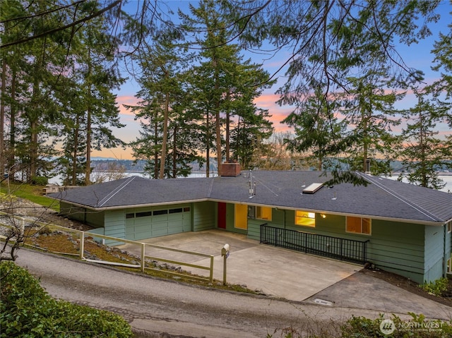 ranch-style house featuring fence, roof with shingles, a chimney, driveway, and an attached garage