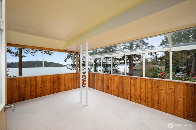 unfurnished sunroom featuring a water view