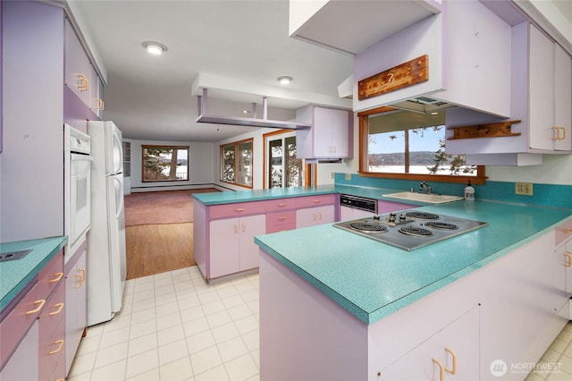 kitchen with white appliances, a peninsula, light tile patterned flooring, a sink, and white cabinets