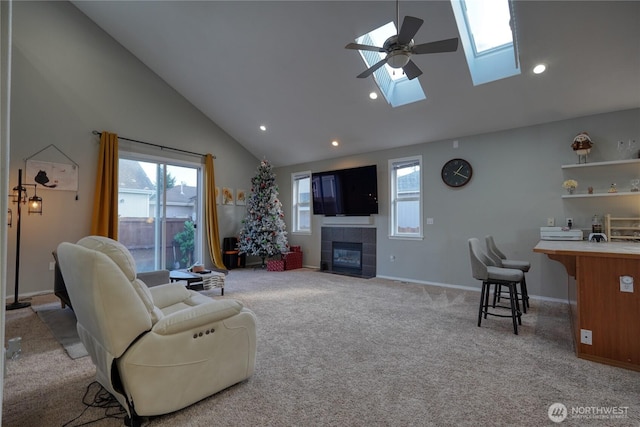 living room featuring a healthy amount of sunlight, a skylight, a fireplace, and light carpet