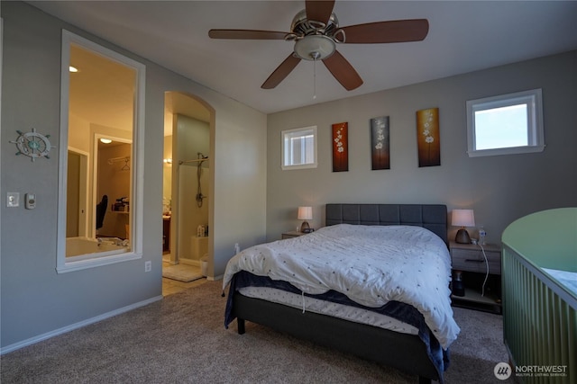 bedroom featuring ensuite bath, baseboards, carpet floors, and ceiling fan