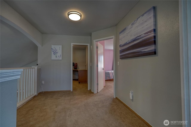 hallway featuring baseboards and carpet floors